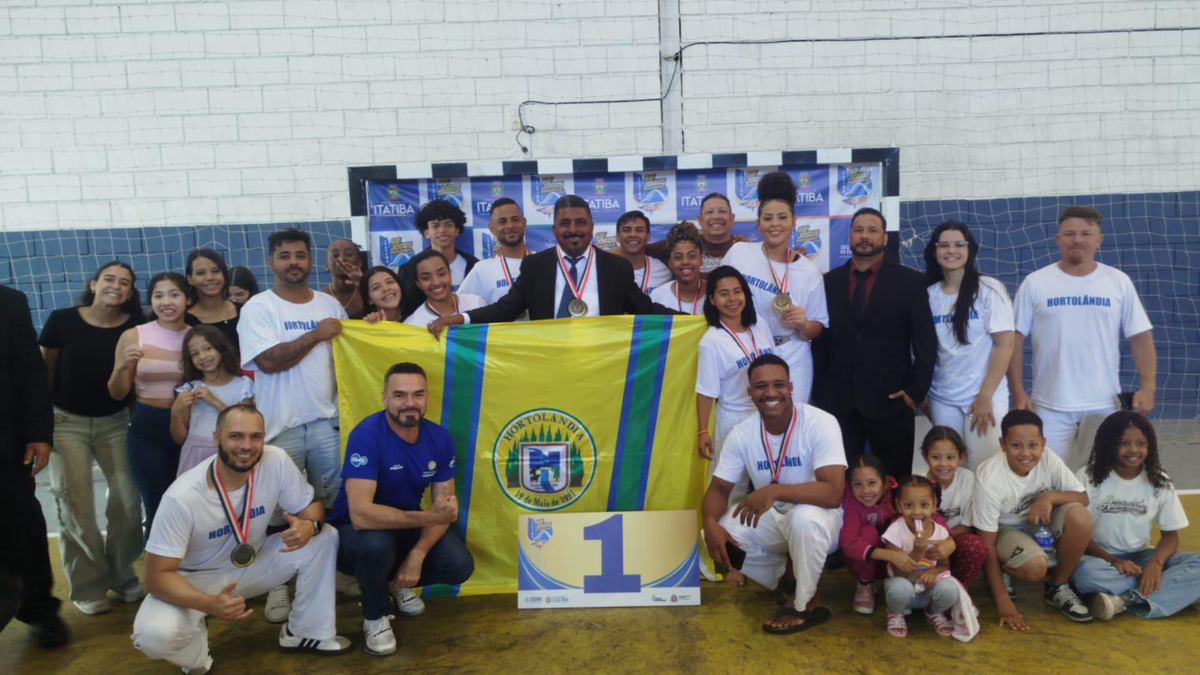 Equipe de capoeira de Hortolândia posa com medalhas e a bandeira do município